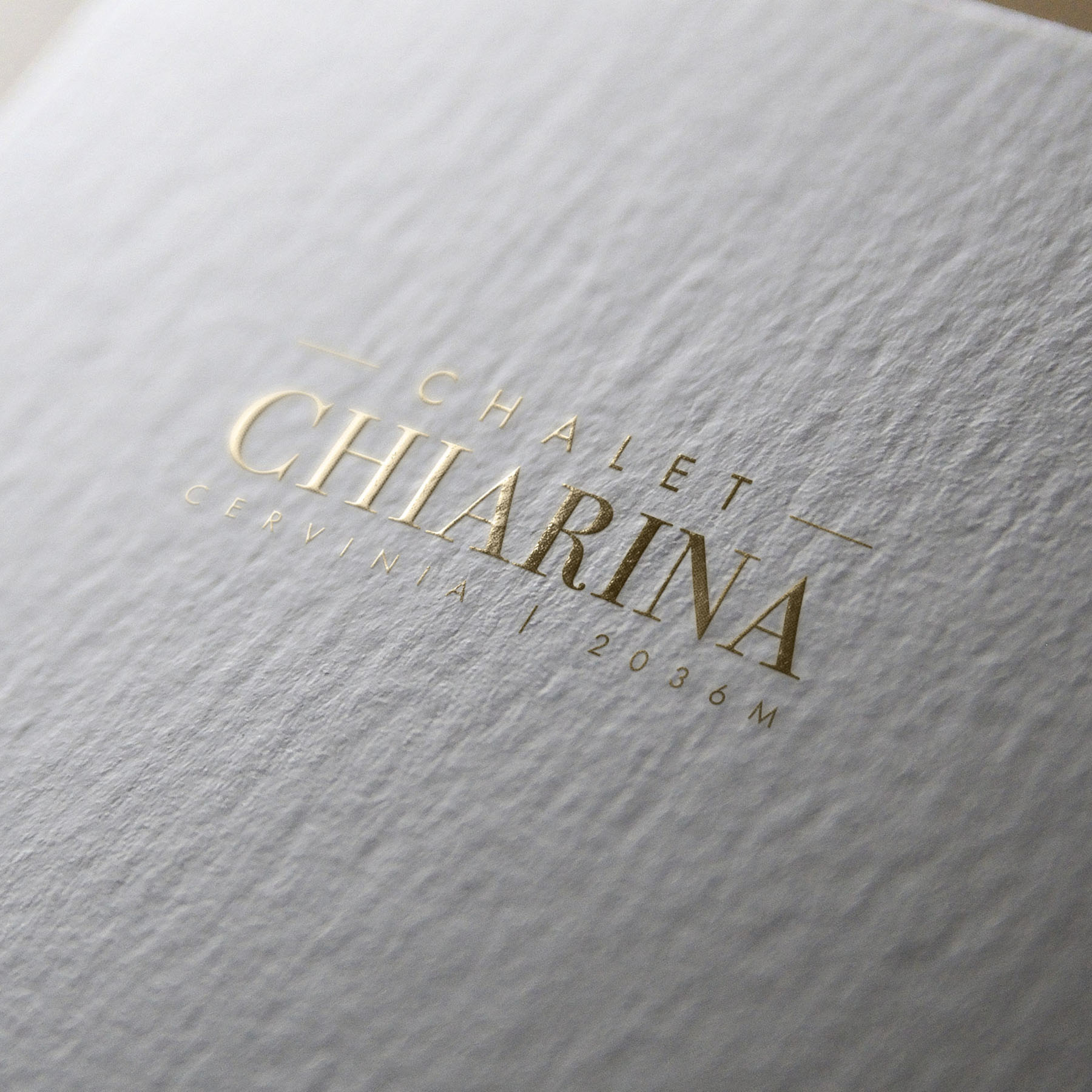 luxury chalet cervinia brand identity design - gold foil text on a textured background